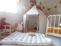 a child's bedroom with a tent bed, rocking chair and stuffed animals on the floor