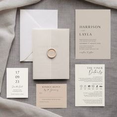 the wedding stationery is laid out neatly on top of the linens and paper