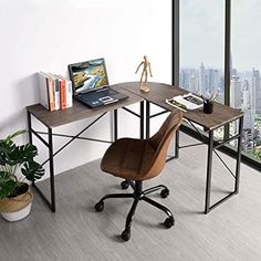 an office desk with a laptop computer on it and a plant in front of the window