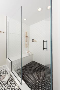 a bathroom with black and white tile flooring, shower stall and bathtub area