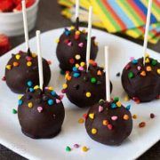 chocolate covered cake pops with sprinkles on a plate