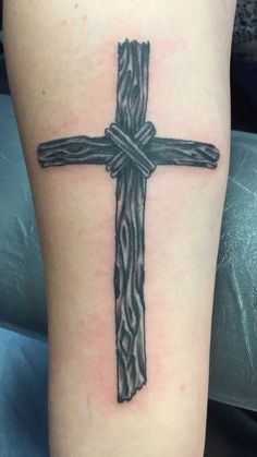 a cross tattoo on the leg of a person