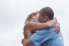 a man and woman embracing each other on the beach