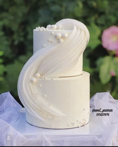 a white wedding cake sitting on top of a table