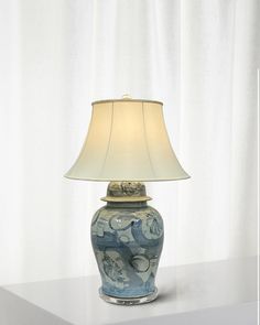 a blue and white lamp sitting on top of a table