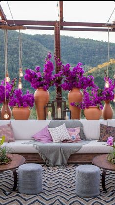 an outdoor seating area with potted plants and pillows