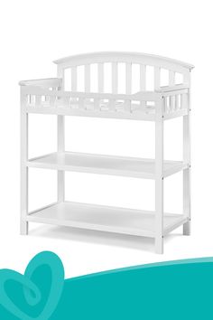 a white baby crib with shelves on the bottom and bottom shelf in front of it