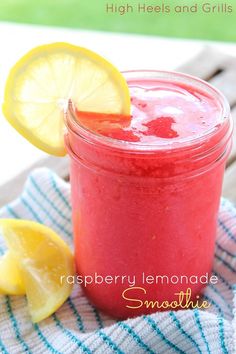 a close up of a mason jar filled with liquid and lemons on a towel