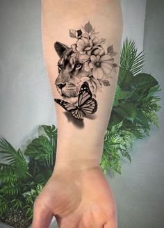 a woman's arm with a tattoo on it that has a tiger and flowers on it