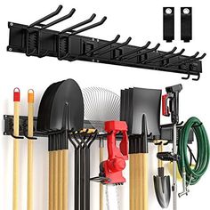 an assortment of tools hanging from a rack on a wall with hooks and hoses attached to it