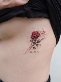 a woman's stomach with a rose tattoo on it