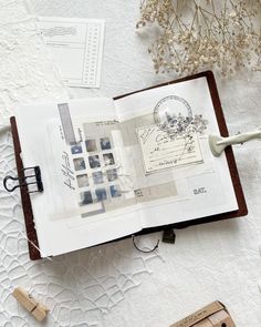 an open book sitting on top of a table next to some rubber stamps and a pair of scissors