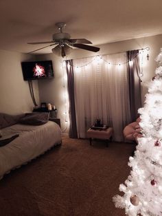 a white christmas tree with lights in a bedroom