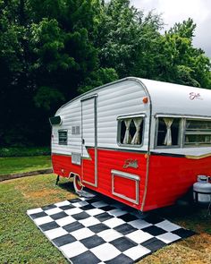 a red and white trailer parked on top of a checkered black and white floor