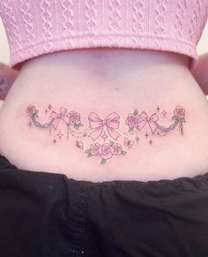 a woman's lower back tattoo with pink bows and stars on her stomach,