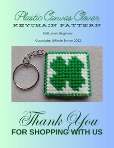 a green and white keychain with a shamrock on it, says thank you for shopping