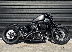 a black motorcycle parked in front of a garage door