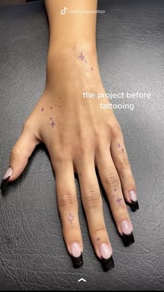 a woman's hand with purple nail polish and stars on her left wrist, the text reads the project before tattooing