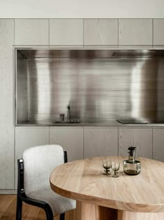 a table with two chairs next to it in front of a stainless steel stove top