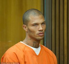 a man in an orange prison uniform looking at the camera with tattoos on his face