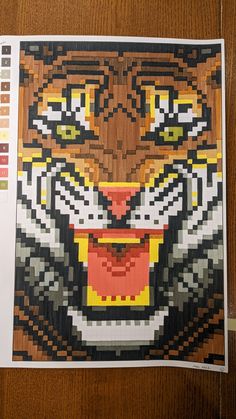 a piece of art made to look like a tiger's face on a wooden surface