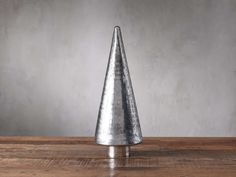 a metal cone shaped object sitting on top of a wooden table