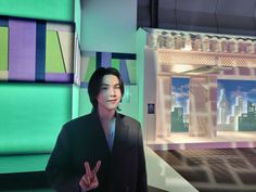 a man standing in front of a green and purple building with buildings on the other side