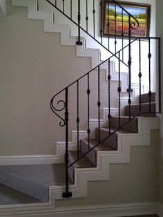 a painting hangs on the wall next to a stair case