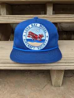 Vintage 80's 90's Long Bay Model Aircraft Society Snapback Rope Hat. Has normal vintage wear. Has crease behind patch. NO holes. In good vintage condition... Ready To Wear!! One Size Fits Most. Retro Trucker Hat With Logo Patch, Vintage 5-panel Trucker Hat With Logo Patch, Retro Snapback Hat With Logo Patch And Curved Brim, Vintage Blue Snapback Hat With Flat Brim, Vintage Blue Trucker Hat, Retro 5-panel Baseball Cap For The Beach, Vintage Trucker Hat With Logo Patch, Retro 5-panel Baseball Cap For Beach, Vintage Trucker Hat With Logo Patch And Flat Brim