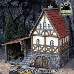 a miniature model of a medieval house in front of a mountain