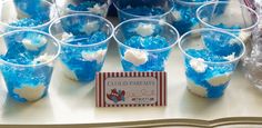 blue and white desserts in plastic cups on a table with a sign that says cold parfaits