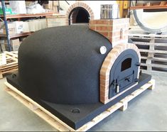 an outdoor brick pizza oven on pallets in a warehouse