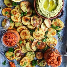 an assortment of baked potatoes and dips on a tray