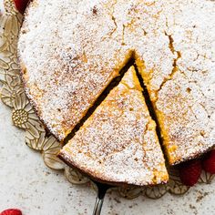 a cake that has been cut into slices and is on a plate with raspberries