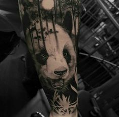 a black and white photo of a panda bear in the woods with trees on his arm