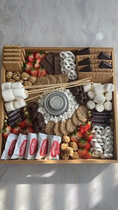 a wooden box filled with lots of different types of food and snacks on top of a table