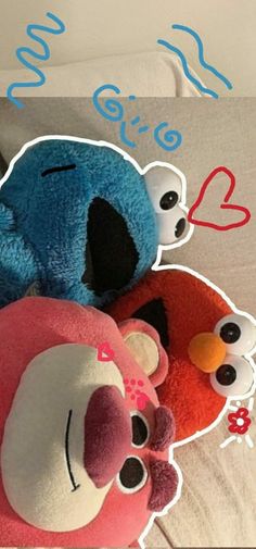 two stuffed animals laying next to each other on top of a bed with blue and red hearts