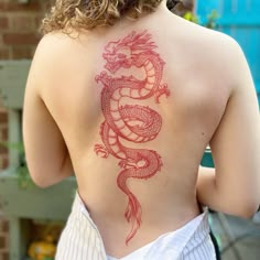 a woman with a dragon tattoo on her back