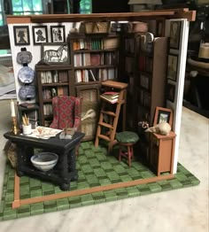 a doll house with furniture and bookshelves on the floor in front of it