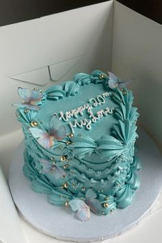 a birthday cake with blue frosting and butterflies on it