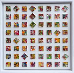 a white framed artwork with many different colored squares on the bottom and one square in the middle