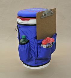 a blue trash can with its lid open and some items in the back pocket attached to it