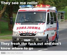 an ambulance is driving down the road with two people in it's back seat