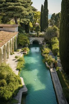 an outdoor swimming pool surrounded by greenery and stone walkways with trees on either side