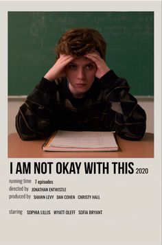 a young man sitting at a desk in front of a blackboard with the words i am not okay with this