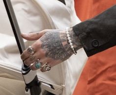 a person with tattoos on their arm holding onto a white bag and wearing an orange shirt