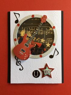 a red guitar and musical notes on a card