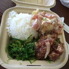 a takeout container with rice, meat and vegetables