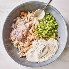 a bowl filled with chicken, celery, and pita chips on top of a table