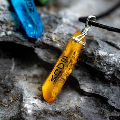 a yellow piece of glass sitting on top of a rock next to a black cord